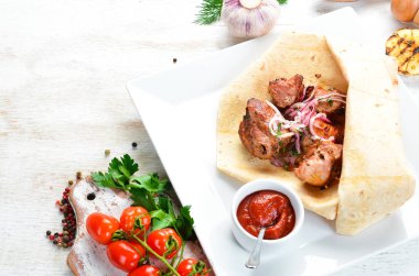 Pita ekmeğinde soğanlı dana kebabı. Et şişleri. Üst görünüm.