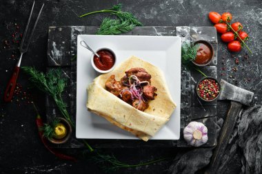 Pita ekmeğinde soğanlı dana kebabı. Et şişleri. Üst görünüm.