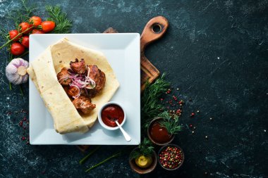 Pita ekmeğinde soğanlı dana kebabı. Et şişleri. Üst görünüm.