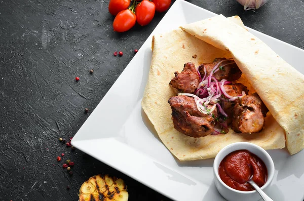 Veal kebab with onions in pita bread. Meat skewers. Top view.
