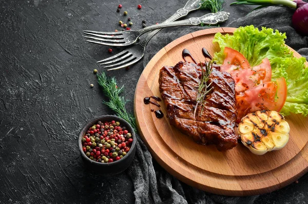 ボード上の野菜とジューシーな焼きポークステーキ トップ表示 — ストック写真