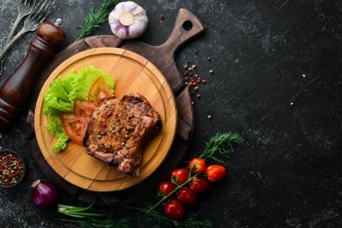 Kemiğin üzerinde biftek ve tahtada sebze. Barbekü menüsü. Üst görünüm.