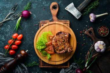 Kemiğin üzerinde biftek ve tahtada sebze. Barbekü menüsü. Üst görünüm.