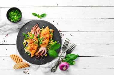 Siyah taş tabakta pilav ve sebzeli kalamar. Deniz ürünleri. Üst Manzara. Boş kopyalama alanı.