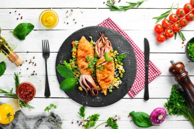 Siyah taş tabakta pilav ve sebzeli kalamar. Deniz ürünleri. Üst Manzara. Boş kopyalama alanı.