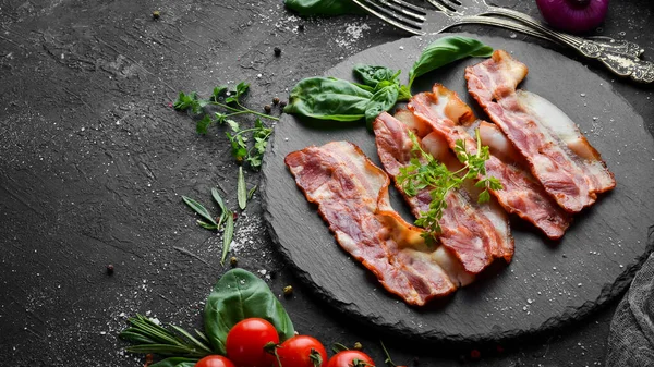 Siyah taş tabakta fesleğenli kızarmış pastırma dilimleri. Üst Manzara. Boş kopyalama alanı.