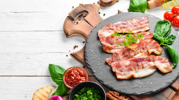 Siyah taş tabakta fesleğenli kızarmış pastırma dilimleri. Üst Manzara. Boş kopyalama alanı.