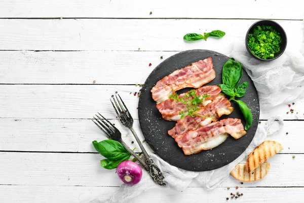 Siyah taş tabakta fesleğenli kızarmış pastırma dilimleri. Üst Manzara. Boş kopyalama alanı.