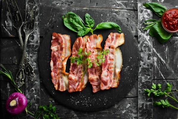 Siyah taş tabakta fesleğenli kızarmış pastırma dilimleri. Üst Manzara. Boş kopyalama alanı.