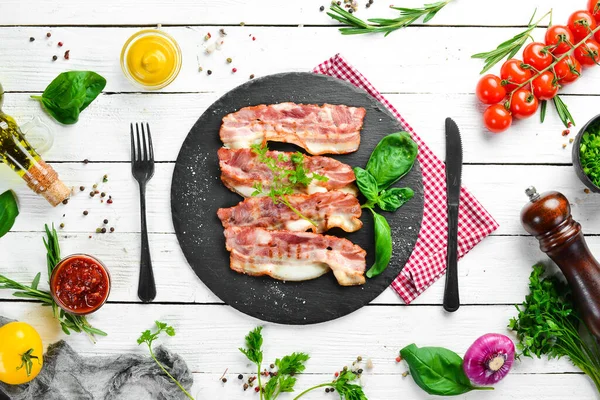 Siyah taş tabakta fesleğenli kızarmış pastırma dilimleri. Üst Manzara. Boş kopyalama alanı.