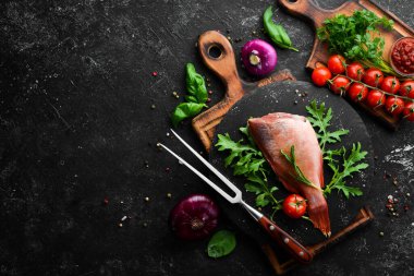 Çiğ deniz kırmızı levreği, biberiye ve siyah tabakta baharatlar. Deniz ürünleri. Üst Manzara. Metnin için boş yer.