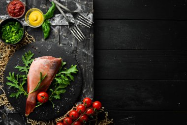 Çiğ deniz kırmızı levreği, biberiye ve siyah tabakta baharatlar. Deniz ürünleri. Üst Manzara. Metnin için boş yer.