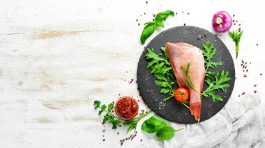 Çiğ deniz kırmızı levreği, biberiye ve siyah tabakta baharatlar. Deniz ürünleri. Üst Manzara. Metnin için boş yer.