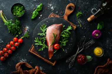 Çiğ deniz kırmızı levreği, biberiye ve siyah tabakta baharatlar. Deniz ürünleri. Üst Manzara. Metnin için boş yer.