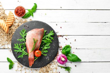 Çiğ deniz kırmızı levreği, biberiye ve siyah tabakta baharatlar. Deniz ürünleri. Üst Manzara. Metnin için boş yer.