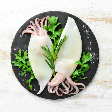 Biberiyeli çiğ mürekkep balığı ve siyah tabakta baharat. Deniz ürünleri. Üst Manzara. Metnin için boş yer.