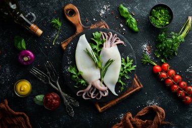 Biberiyeli çiğ mürekkep balığı ve siyah tabakta baharat. Deniz ürünleri. Üst Manzara. Metnin için boş yer.