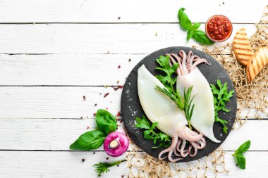 Biberiyeli çiğ mürekkep balığı ve siyah tabakta baharat. Deniz ürünleri. Üst Manzara. Metnin için boş yer.