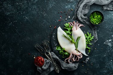 Biberiyeli çiğ mürekkep balığı ve siyah tabakta baharat. Deniz ürünleri. Üst Manzara. Metnin için boş yer.