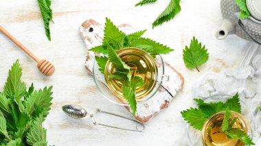 Çaydanlık ve fincanla bitki çayı. Taze ısırgan otu çayı. Üst Manzara. Metnin için boş yer.