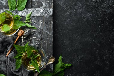 Bardakta ısırgan otu çayı. Bağışıklık kazandıran bitkisel içecekler. Üst Manzara. Metnin için boş yer.