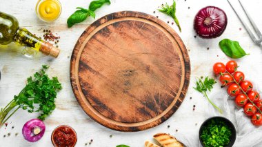 Yemek arkaplanı. Mutfak tahtası, sebzeler, baharatlar ve mutfak gereçleri eski masada. Boş kopyalama alanı.