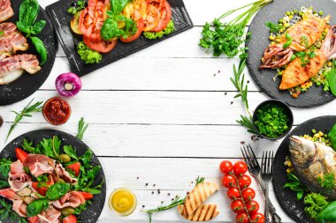 Yiyecekler. Tabakları beyaz masaya koyun. Yemek arkaplanı. Üst Manzara. Boş kopyalama alanı.