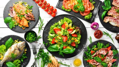 Yiyecekler. Tabakları beyaz masaya koyun. Yemek arkaplanı. Üst Manzara. Boş kopyalama alanı.