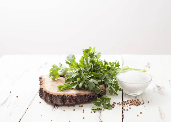 Соль и кориандр, петрушка с семенами на белом деревянном столе — стоковое фото