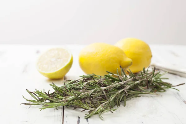 Limão e alecrim na mesa de madeira branca — Fotografia de Stock