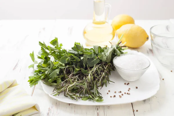Лимон, олія та кінза, насіння петрушки на білому дерев'яному столі — стокове фото