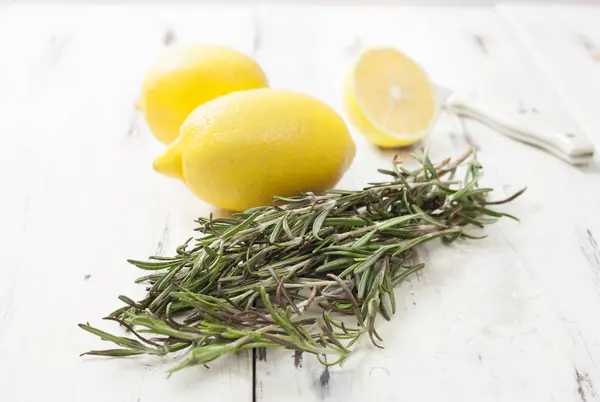 Lemon and rosemary on white wooden table — Stock Photo, Image