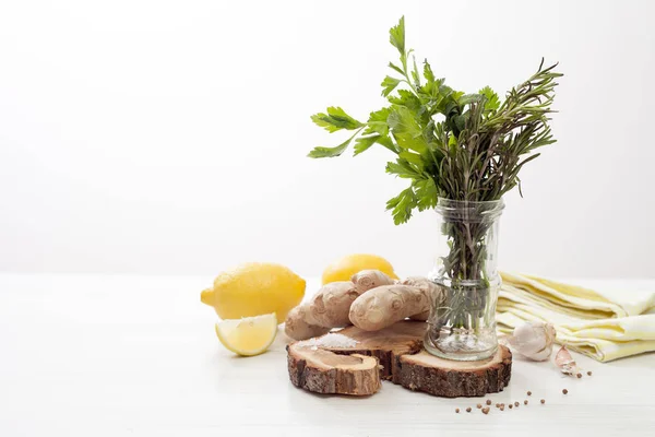 Лимон, имбирь, петрушка, мята и розмарин на белом деревянном столе — стоковое фото