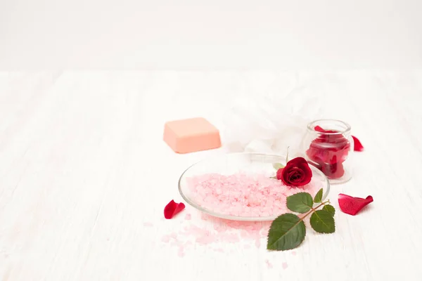 Sal, agua de rosas de pétalos de rosa con las manos en un coro blanco — Foto de Stock