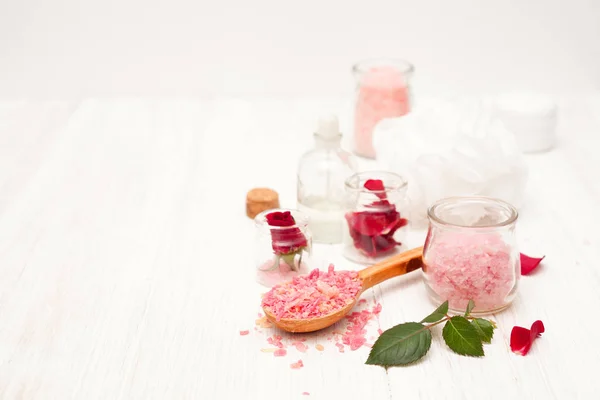 Sal, agua de rosas de pétalos de rosa con las manos en un coro blanco — Foto de Stock