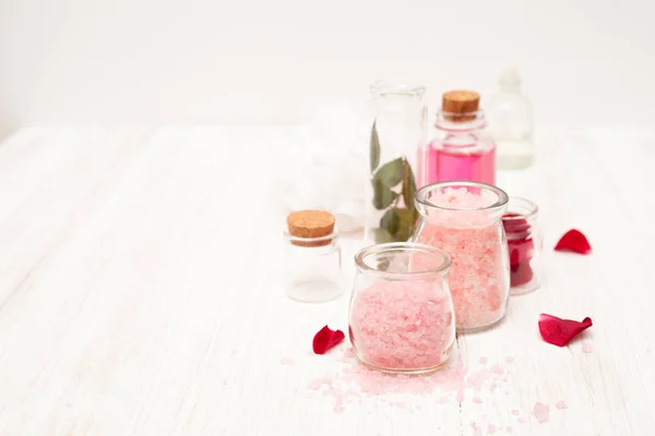 Sal, agua de rosas de pétalos de rosa con las manos en un coro blanco — Foto de Stock