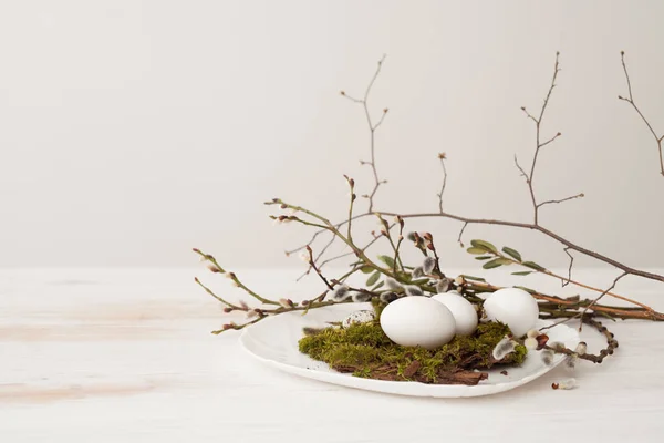 Яйця лежать на тарілці, мох зелений, верби гілки верби, наприклад — стокове фото