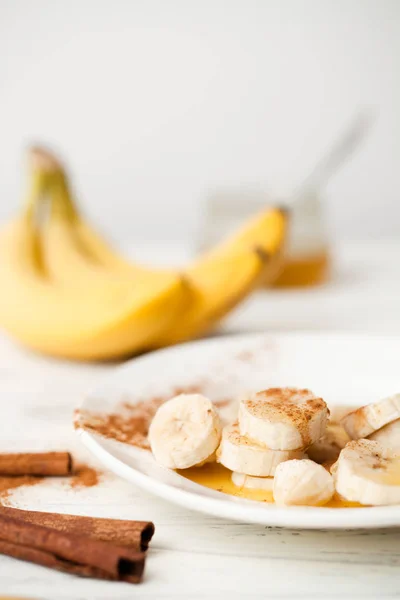 Um monte de bananas e uma banana de corte em um prato . — Fotografia de Stock