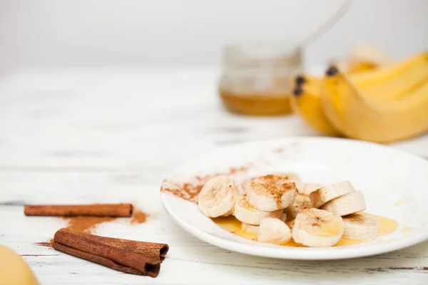 Um monte de bananas e uma banana de corte em um prato . — Fotografia de Stock