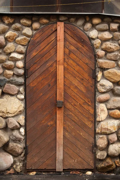 Древняя деревянная дверь с замком в каменной стене — стоковое фото