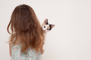 Onu geri ile ayakta ve tutan bir yavru kedi kız