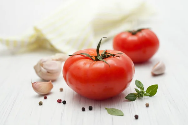 Zwei große rote Tomaten mit Gewürzen auf weißen — Stockfoto