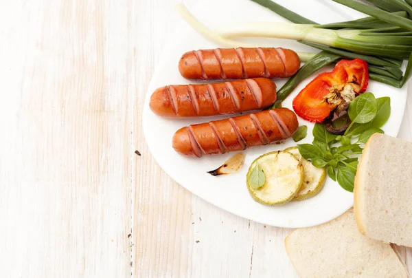 Fried sausages on the barbeque grill on a white — Stock Photo, Image