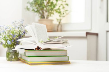 Beyaz bir tablo kitapların bir yığınına