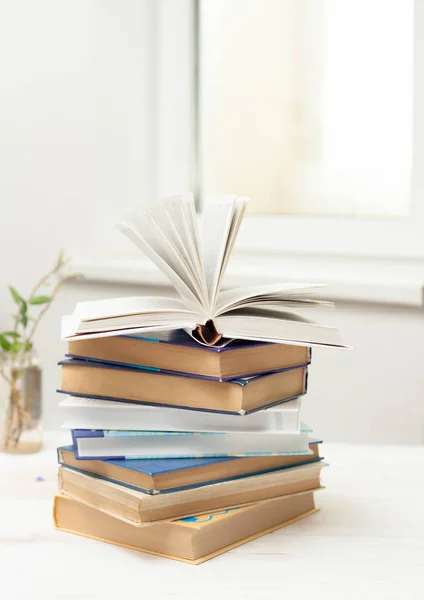 Een stapel boeken op een witte tafel — Stockfoto