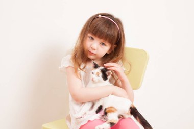 Beyaz bir kedi yavrusu ile oynayan bir çocuk
