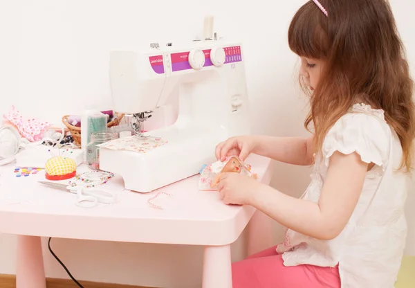 女孩用缝衣服的娃娃从织物件 — 图库照片