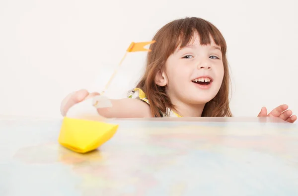 Маленькая девочка играет с бумажными лодками — стоковое фото