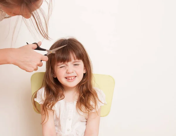 Mother cuts daughter's hair at home Stock Photo by ©ekramar 155782470