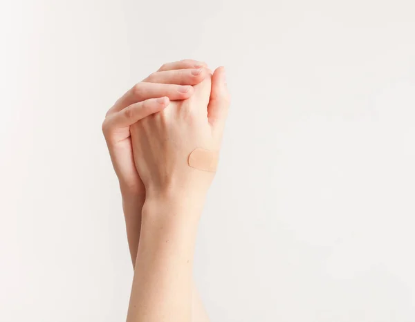 Sticking plaster on hand on white background — Stock Photo, Image